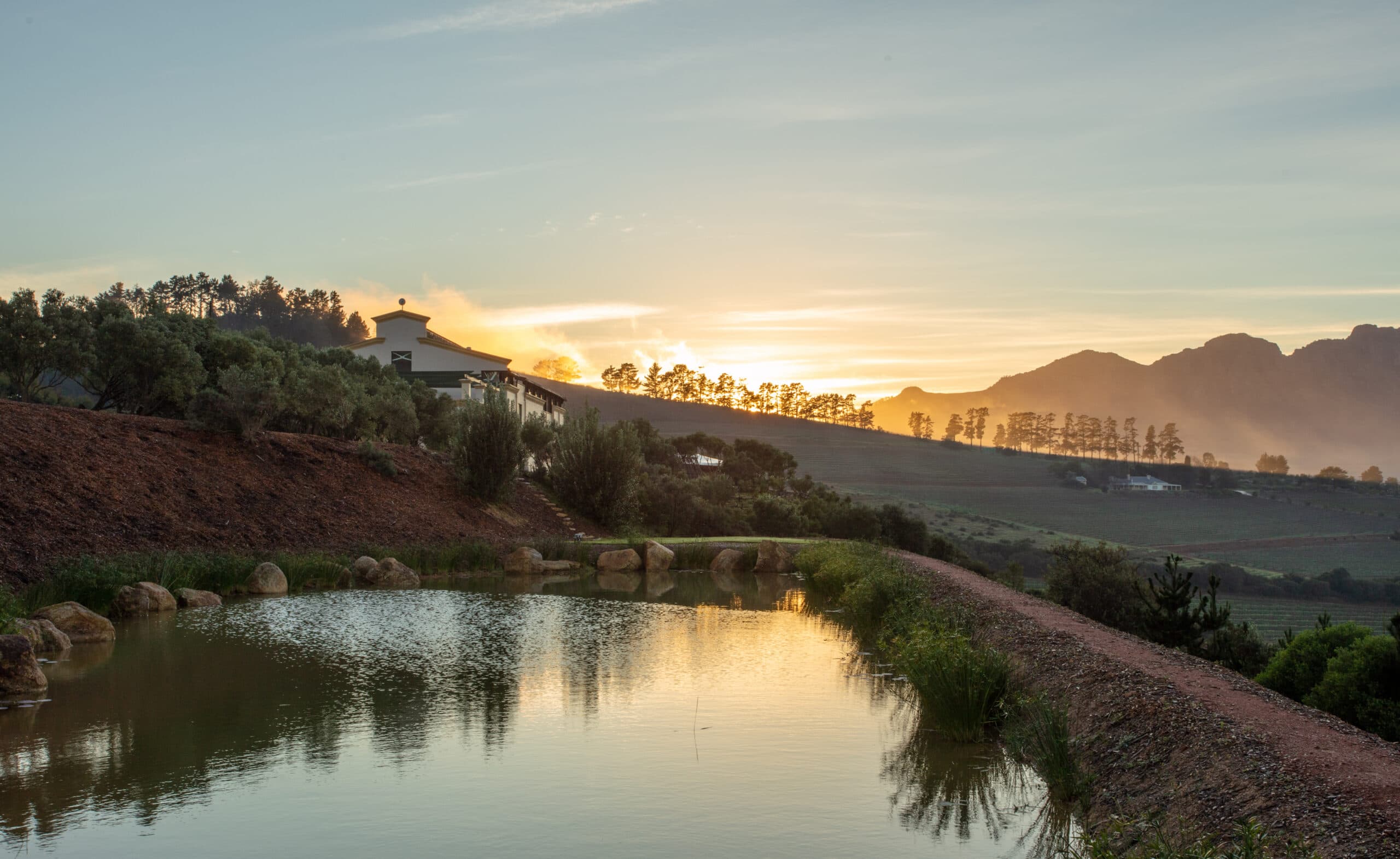 Paisagem da Le Grand Domaine com um lago e montanhas ao fundo.