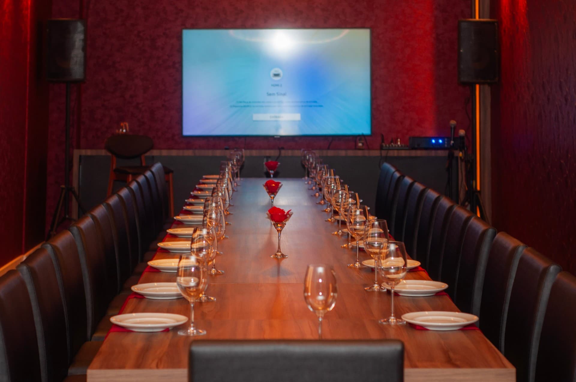 Sala do El Vinos GastroWine com mesa posta, taças e tela para apresentações