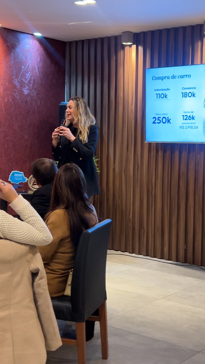 Apresentação de simulação de consórcio no telão durante o evento da Confi Seguros