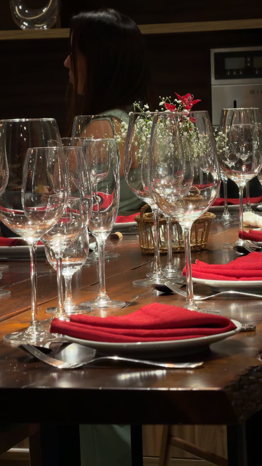 Mesa posta com taças de cristal e guardanapos vermelhos no jantar do Conexão Loft Curitiba