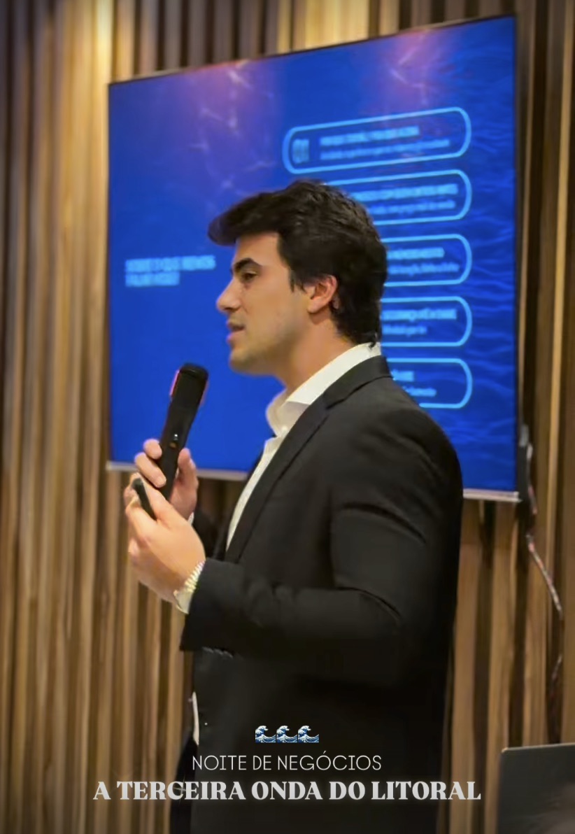 Apresentador ao microfone com empreendimento no telão durante a Noite de Negócios da Rottas